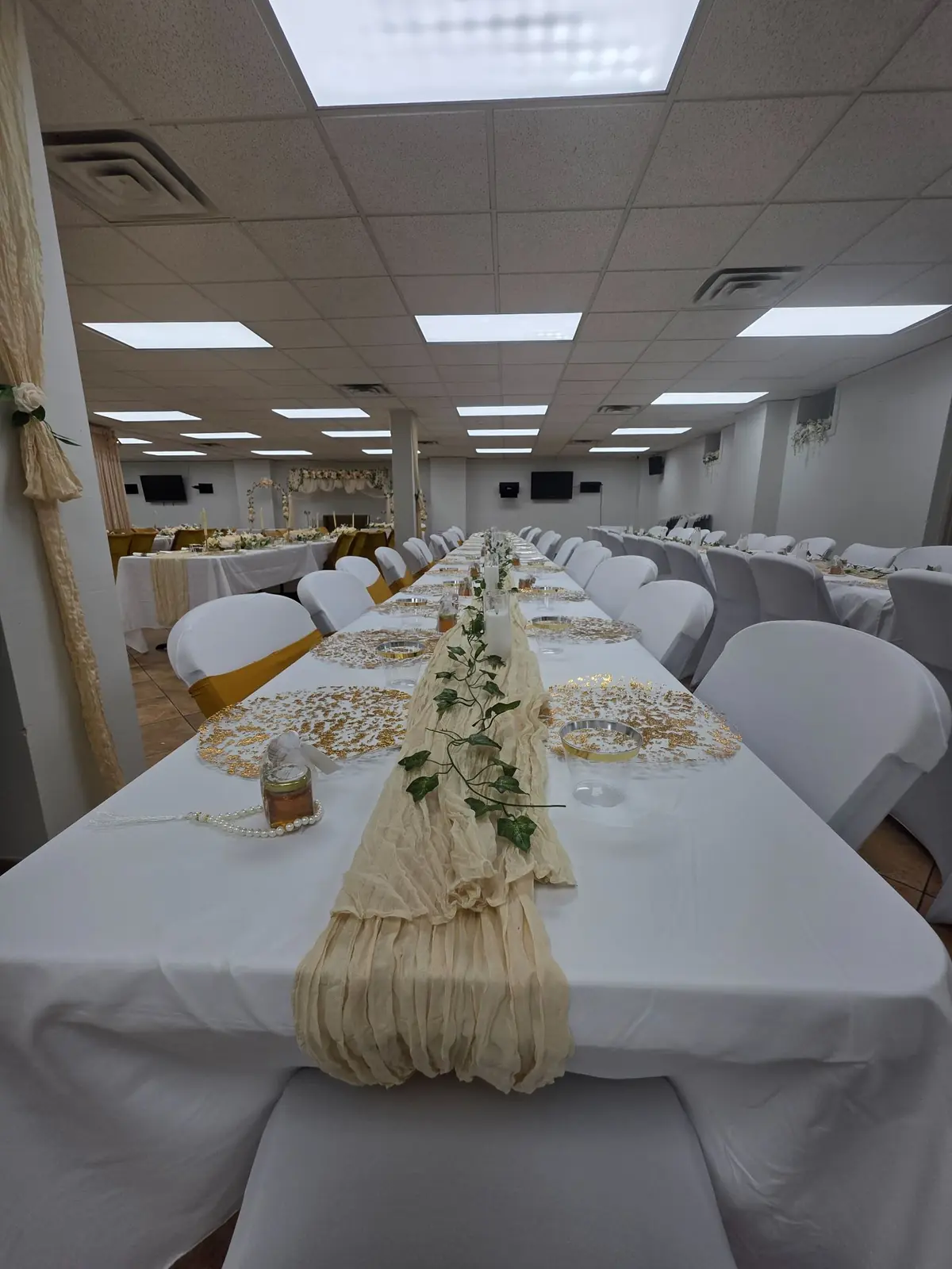 A long table set with place settings and greenery